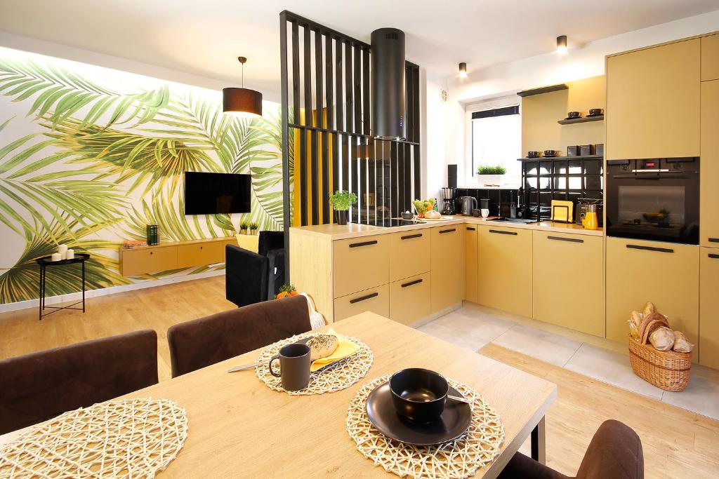 科沙林W&K Apartments - Gold Suite的厨房以及带桌椅的用餐室。
