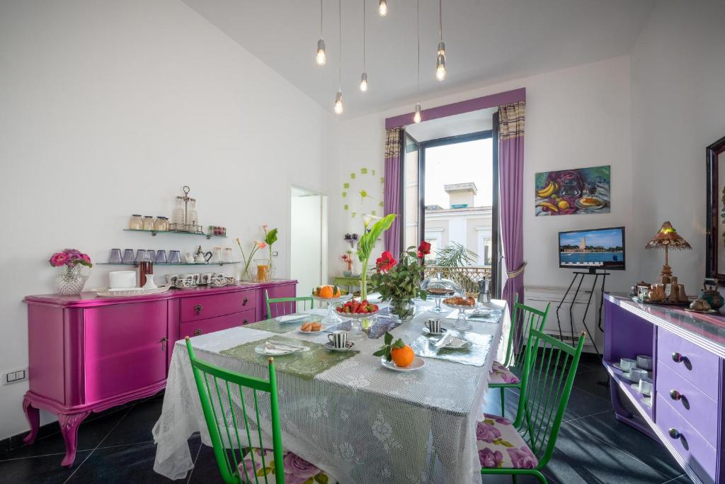 布林迪西Maria Vittoria Charming Rooms and Apartments的厨房配有桌椅和紫色橱柜