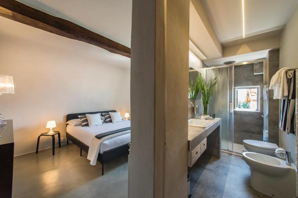 锡耶纳Palazzo del Papa Country Suites的一间卧室配有一张床,浴室设有水槽