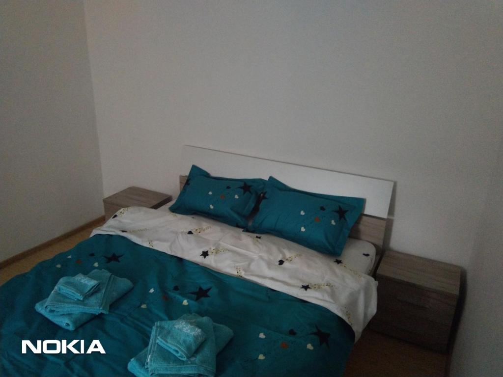 德瓦Cazare的一间卧室配有一张带蓝色床单和蓝色枕头的床。