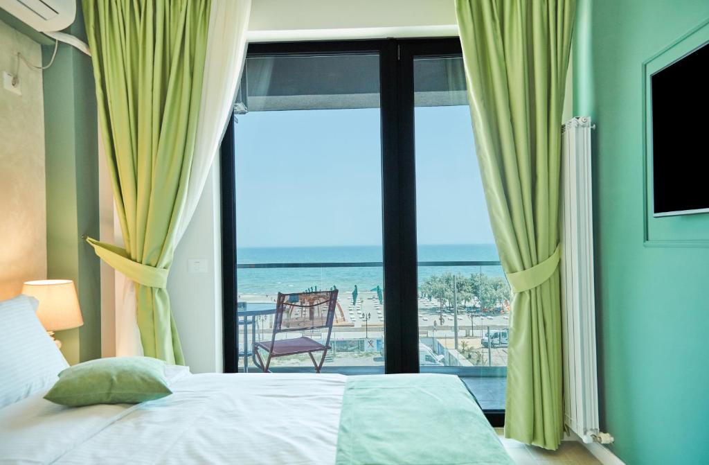 北马马亚-讷沃达里Hotel Excelsior Mamaia Nord的一间卧室配有一张床,享有海滩美景