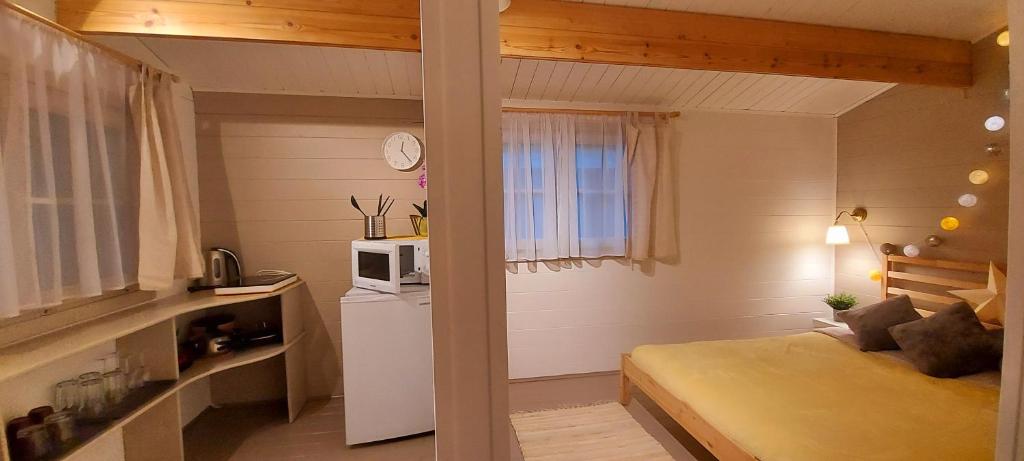 拉脱维亚Kempings Saulkrastos的小房间设有床铺和微波炉