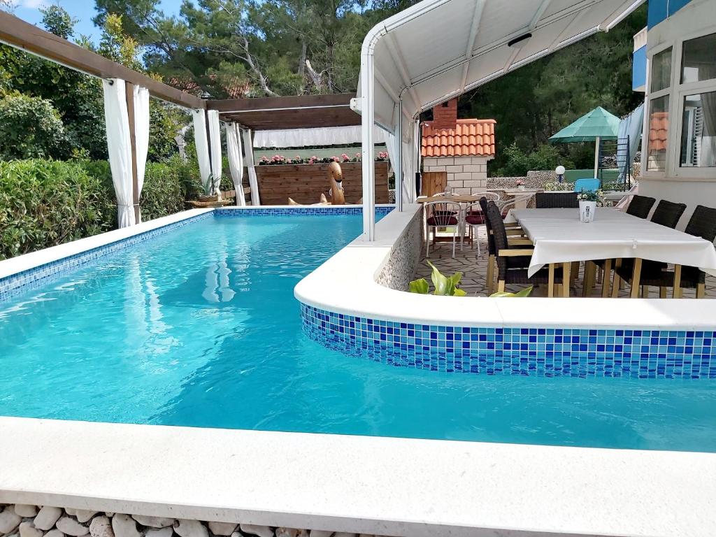 斯拉汀Villa Kale Apartments的一个带桌子和桌子的游泳池以及一个游泳池