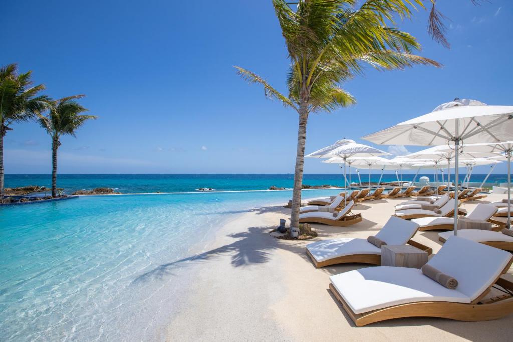 辛普森湾The Morgan Resort Spa & Village的海滩上的一组躺椅和遮阳伞