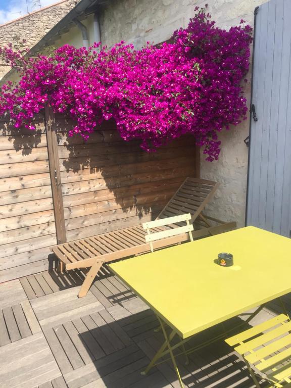 蒙彼利埃Appartements Azema的庭院里种着紫色花,设有桌子和长凳