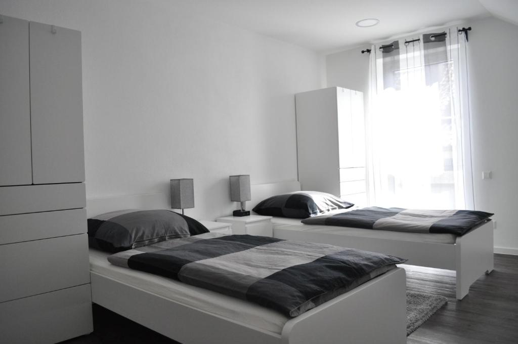 BurgriedenB Home SLEEP & WORK的卧室设有2张床和白色的墙壁。