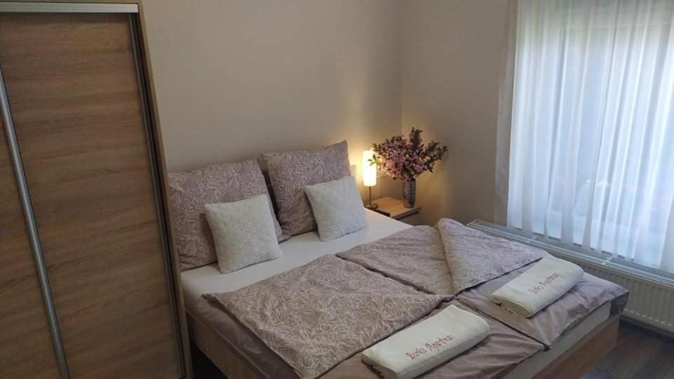 瑙吉考尼饶Barka Apartman的一间卧室配有带白色床单和枕头的床。