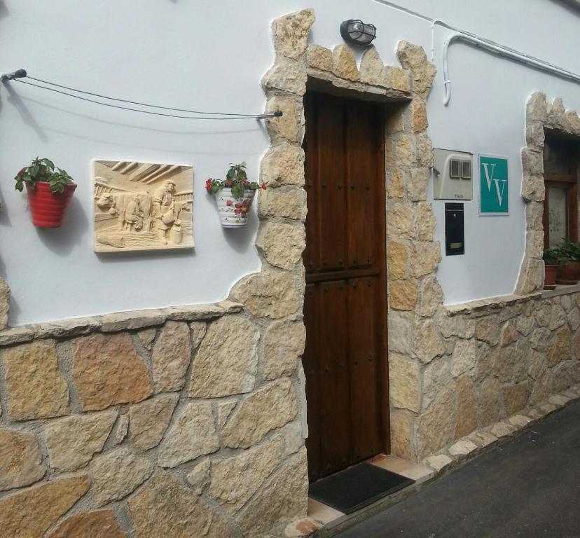 坎加斯-德奥尼斯V.V Casa Mones的石墙内一扇有盆栽植物的门
