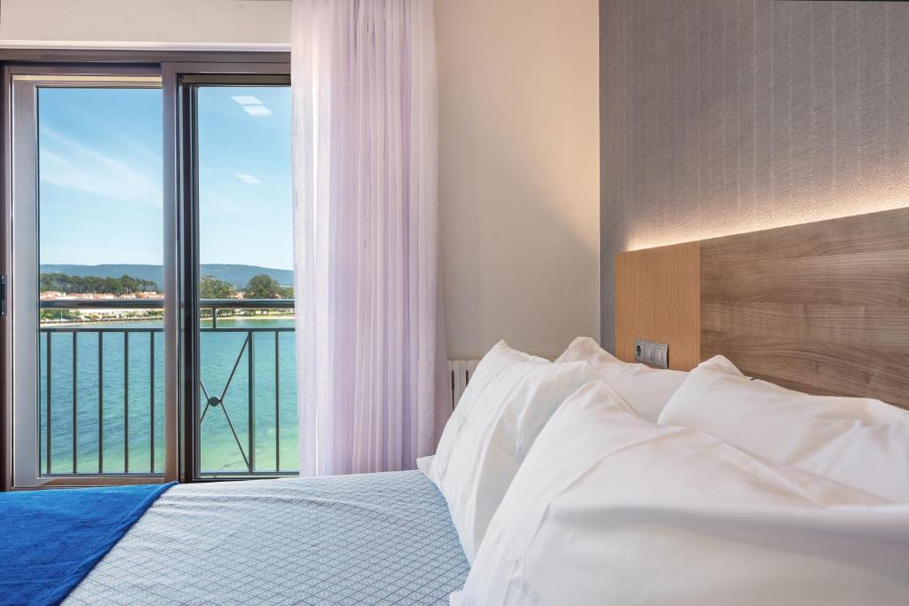格罗韦Hotel Montemar *** Superior的一间卧室配有一张床,享有水景