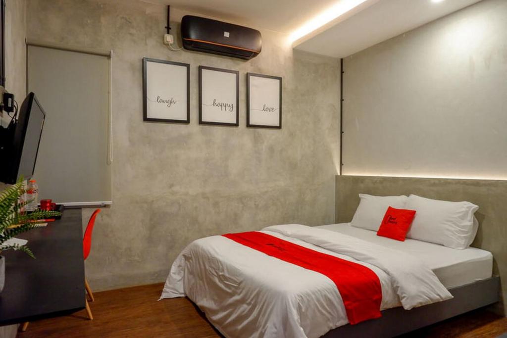三宝垄RedDoorz Plus near Kawasan Sam Poo Kong Semarang的一间卧室配有一张带红白毯子的床