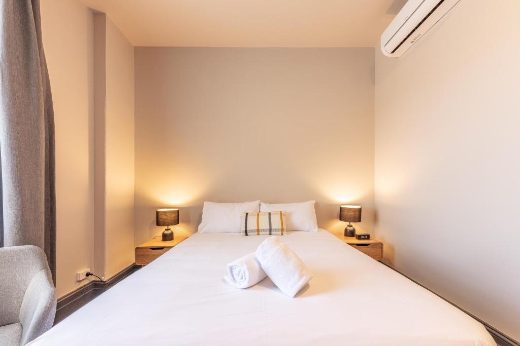 悉尼Lakemba Hotel的一间卧室配有一张带两个枕头的床