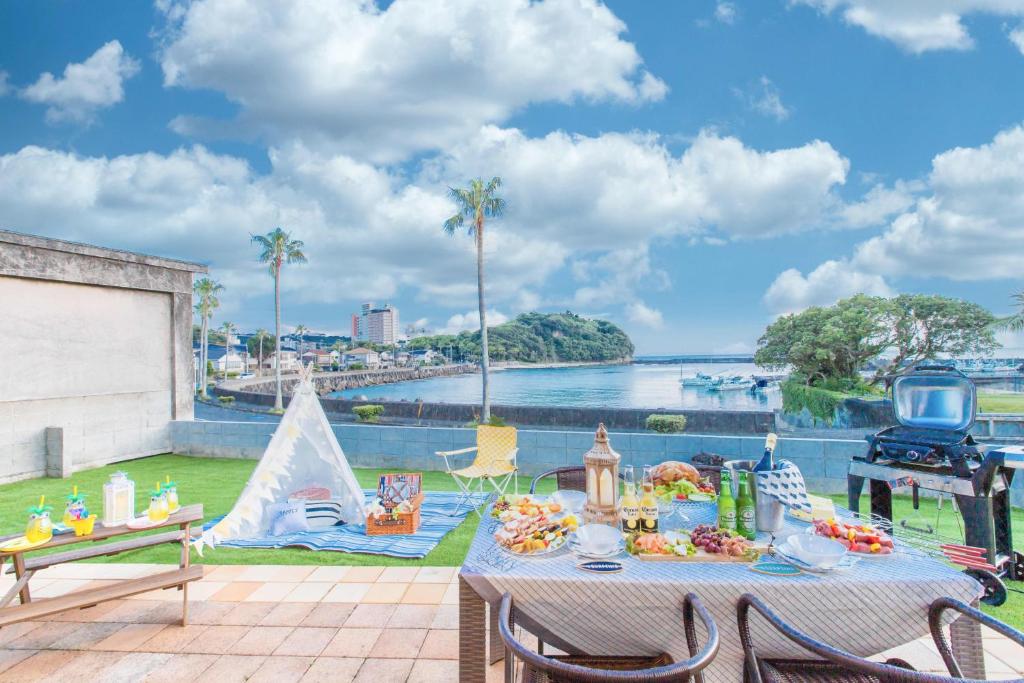 白滨West Coast Villa Shirahama的享有水景的天井上的野餐桌