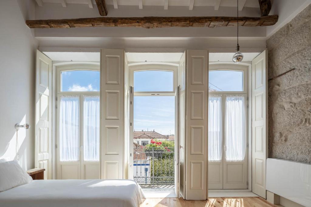 波尔图Uba - Heritage and Wine的一间卧室设有一张床和两个窗户。