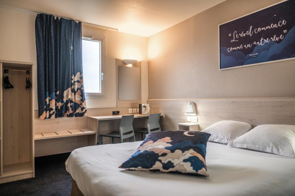 Le Petit-CouronneACE Hôtel Rouen Parc des Expositions的配有一张床、一张书桌和一扇窗户的酒店客房