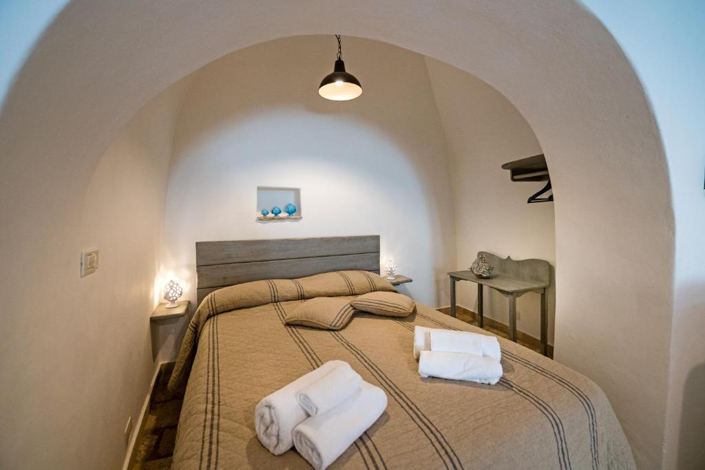 阿尔贝罗贝洛Trullo 11的一间卧室配有一张大床和两条毛巾