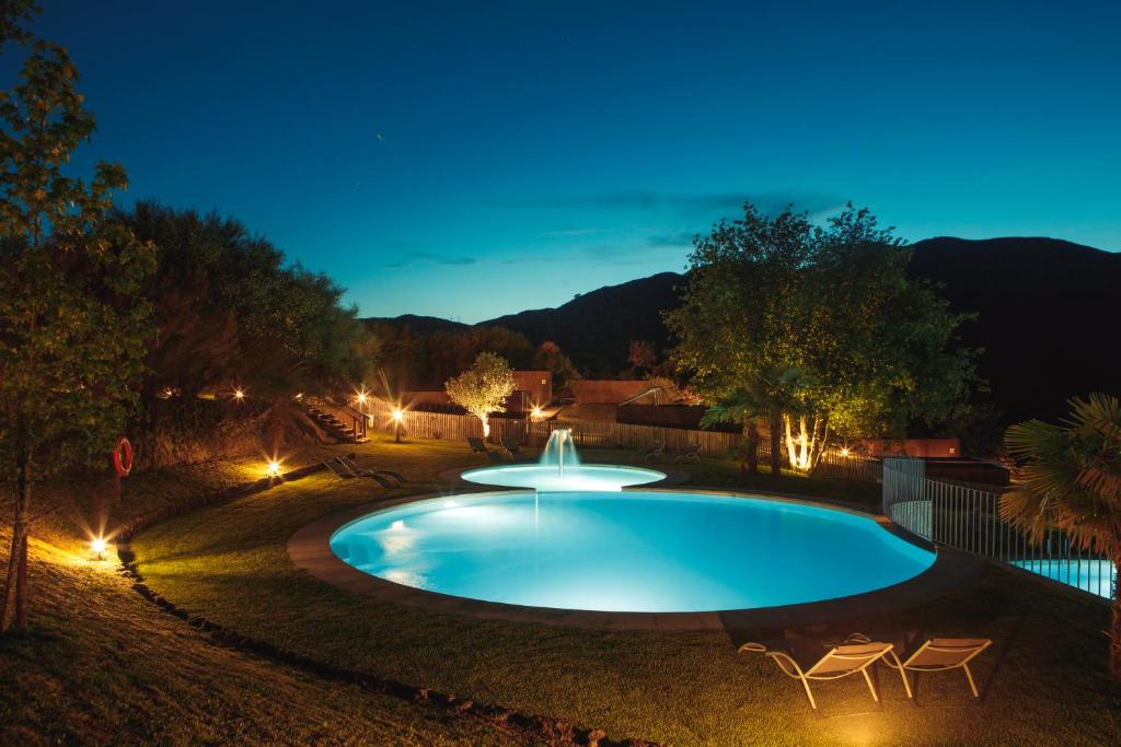 阿尔库什迪瓦尔德维什Eco-Bungalow的夜间在院子里带喷泉的游泳池