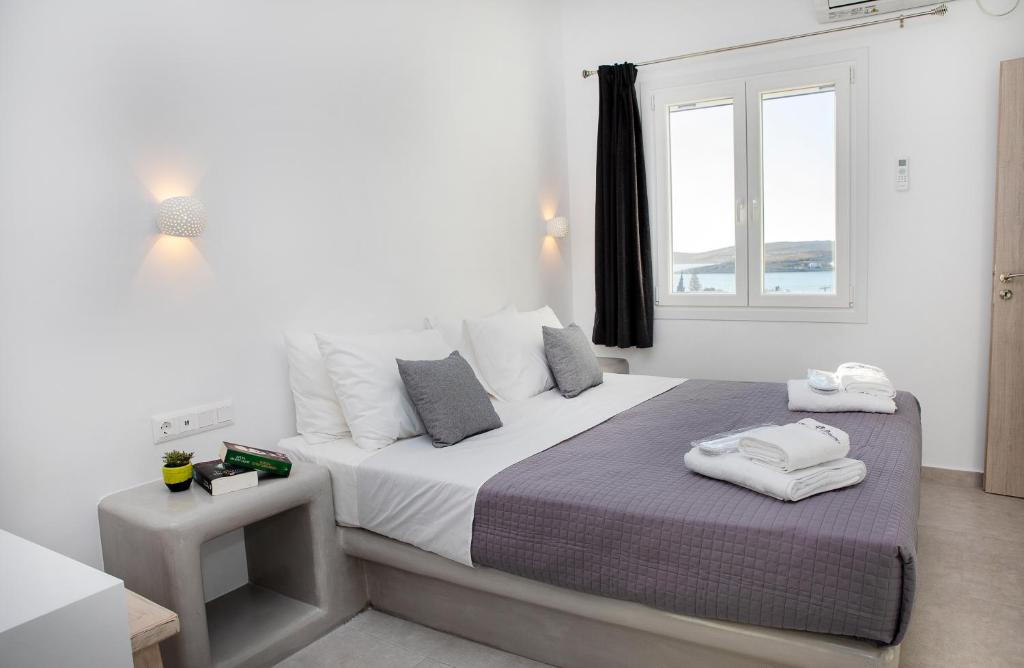 帕罗奇亚Crystal Dreams的一间卧室配有一张带白色床单的床和一扇窗户。