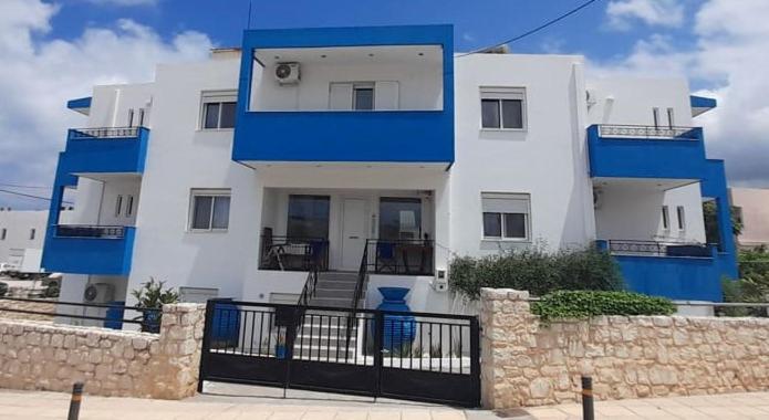 锡蒂亚Emmanouela Studios的蓝色和白色的建筑,前面有栅栏