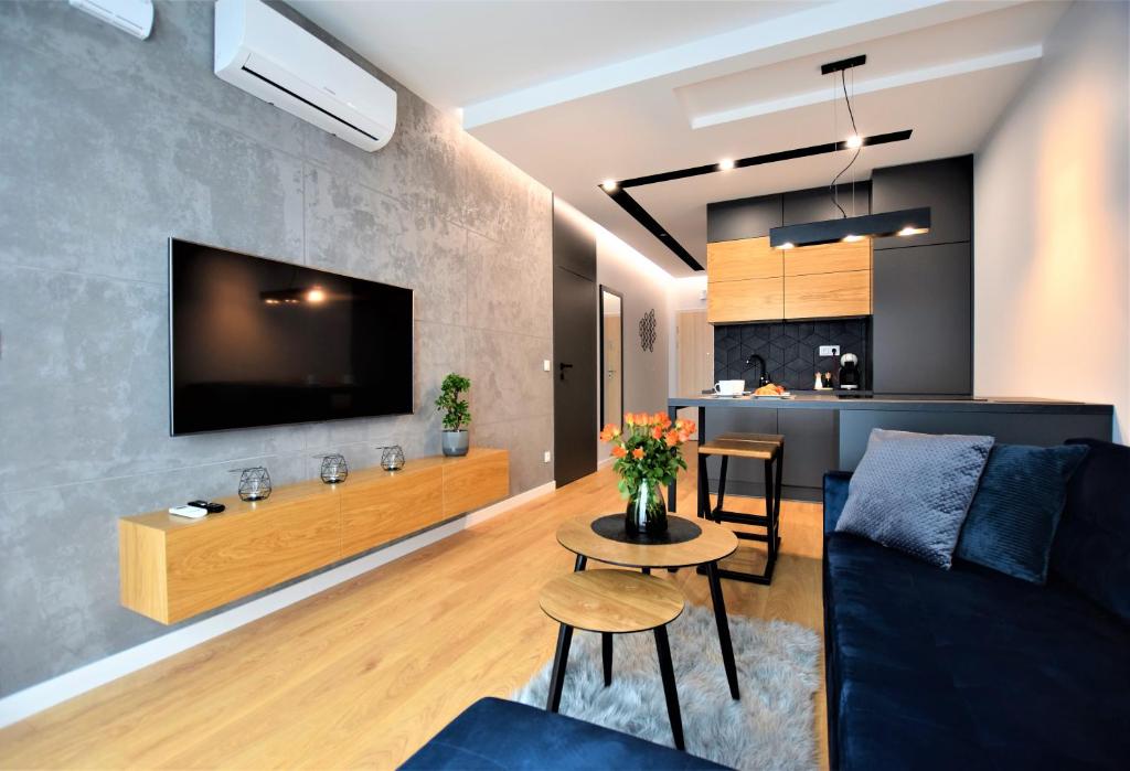 热舒夫Premium Apartments Rzeszów的带沙发、电视和桌子的客厅