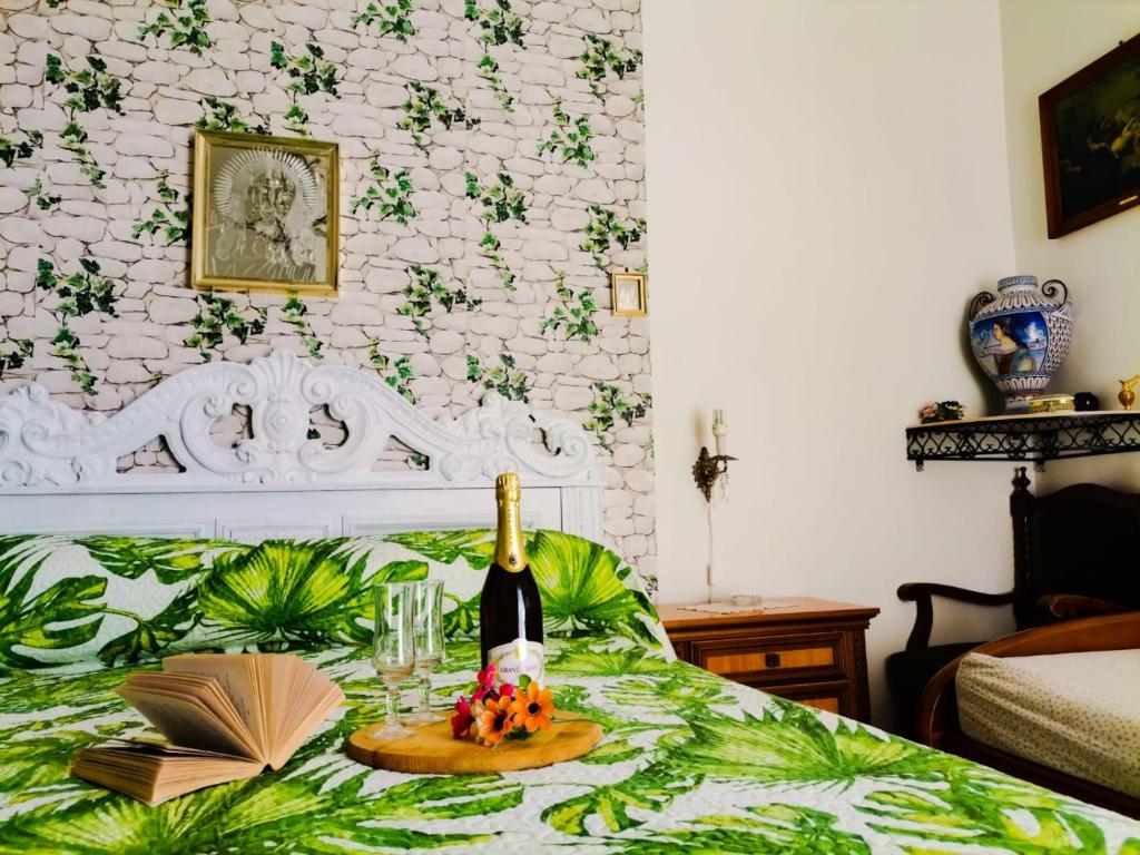 阿特拉尼弗朗西斯之家酒店的一张带一瓶葡萄酒和一盘食物的床