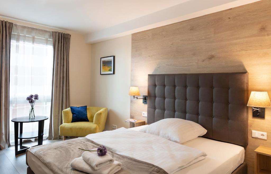 帕德博恩Dominik Hotel & Eventsaal的配有一张床和一把椅子的酒店客房