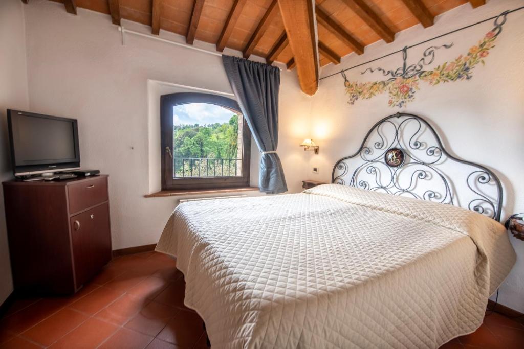 蒙塔尔奇诺奥利维拉韦基亚酒店的卧室配有白色的床和窗户。