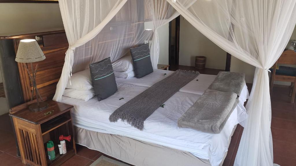 KongolaLianshulu Lodge的卧室配有带白色床单和枕头的天蓬床。