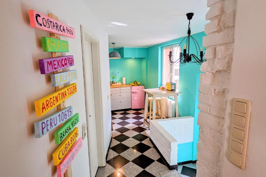 于尔岑Casa de Pancho - Lateinamerika direkt in der City von Uelzen的厨房拥有色彩缤纷的墙壁和门上的标志