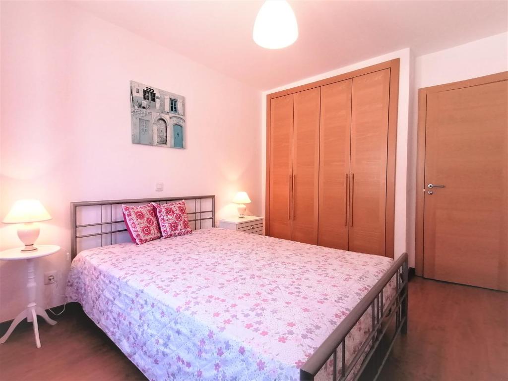 波尔蒂芒Encosta da Marina Beach Apartment的一间卧室设有一张大床和一扇木门