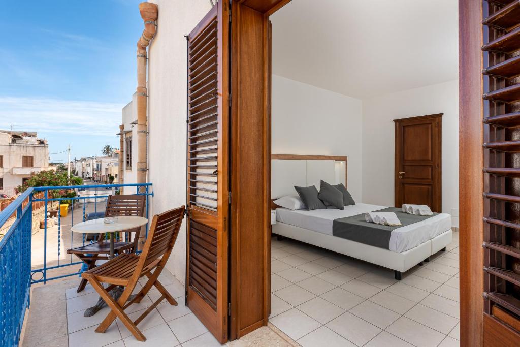圣维托罗卡波置身天堂酒店的一间卧室,阳台上配有一张床和一张桌子