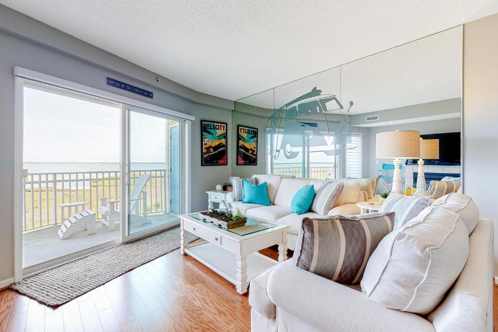 大洋城Playa Flamingo #302的一间带白色沙发的客厅和一个阳台