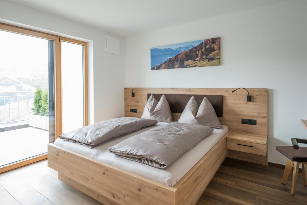 MaretaJaufnerhof的一间卧室配有一张大床和木制床头板