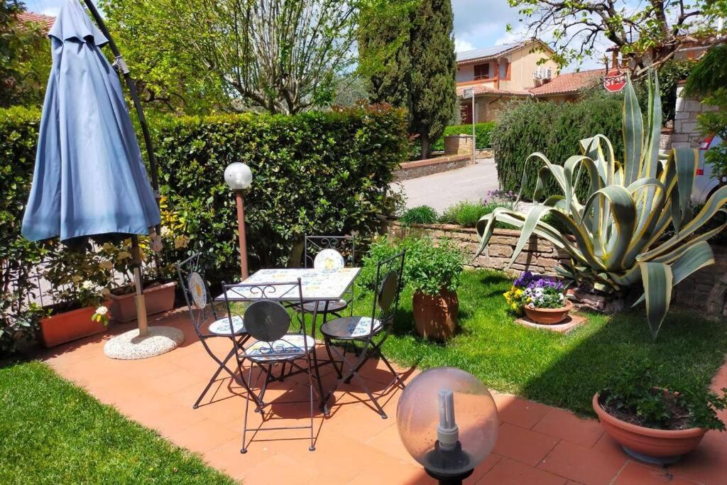 卡斯德尔诺沃贝拉登卡L' Agave - Appartamento nel cuore del Chianti的庭院配有桌椅和遮阳伞。