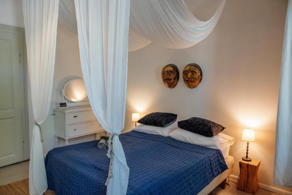 雷夫菲勒普Káli44 Vendégház的卧室配有两张床,墙上有两个面罩
