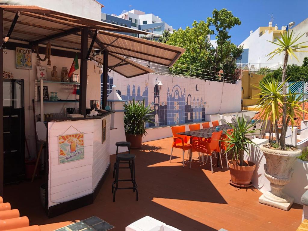 阿尔布费拉奥兰奇特莱斯旅舍的屋顶露台设有酒吧和桌椅