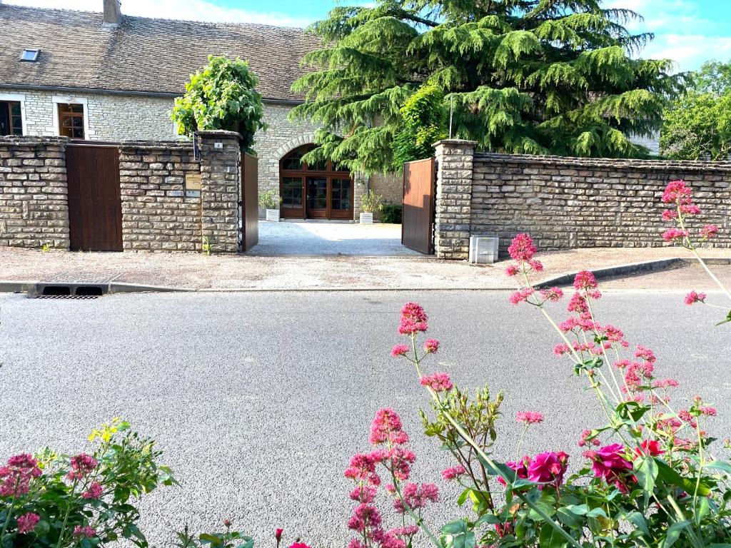 蒙塔尼莱丝比欧尼Maison Belles Pierres的一座房子前面有石墙和鲜花