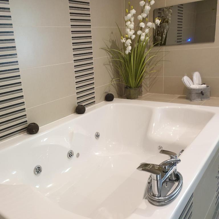 因弗内斯Inverness House的浴室内设有带水龙头的白色浴缸