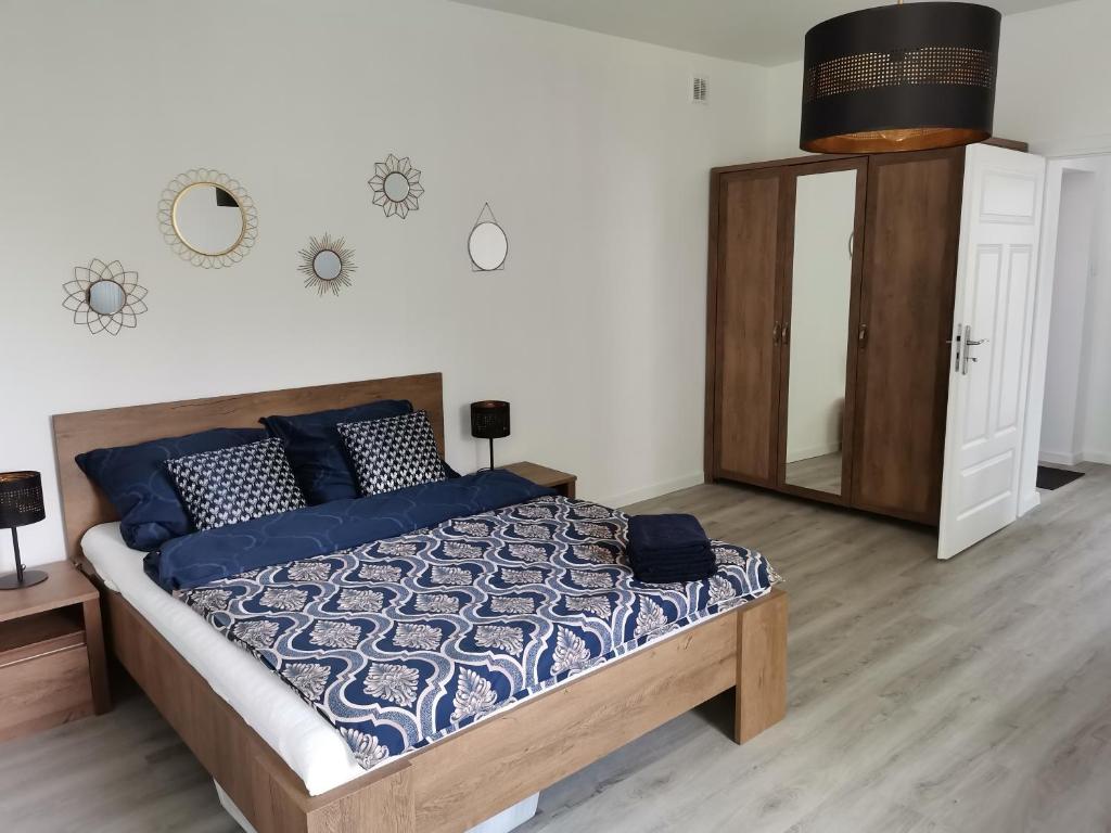 波兹南Kamienica nad Maltą- Mieszkania nad Jeziorem Maltańskim的一间卧室配有一张带蓝色枕头和镜子的床