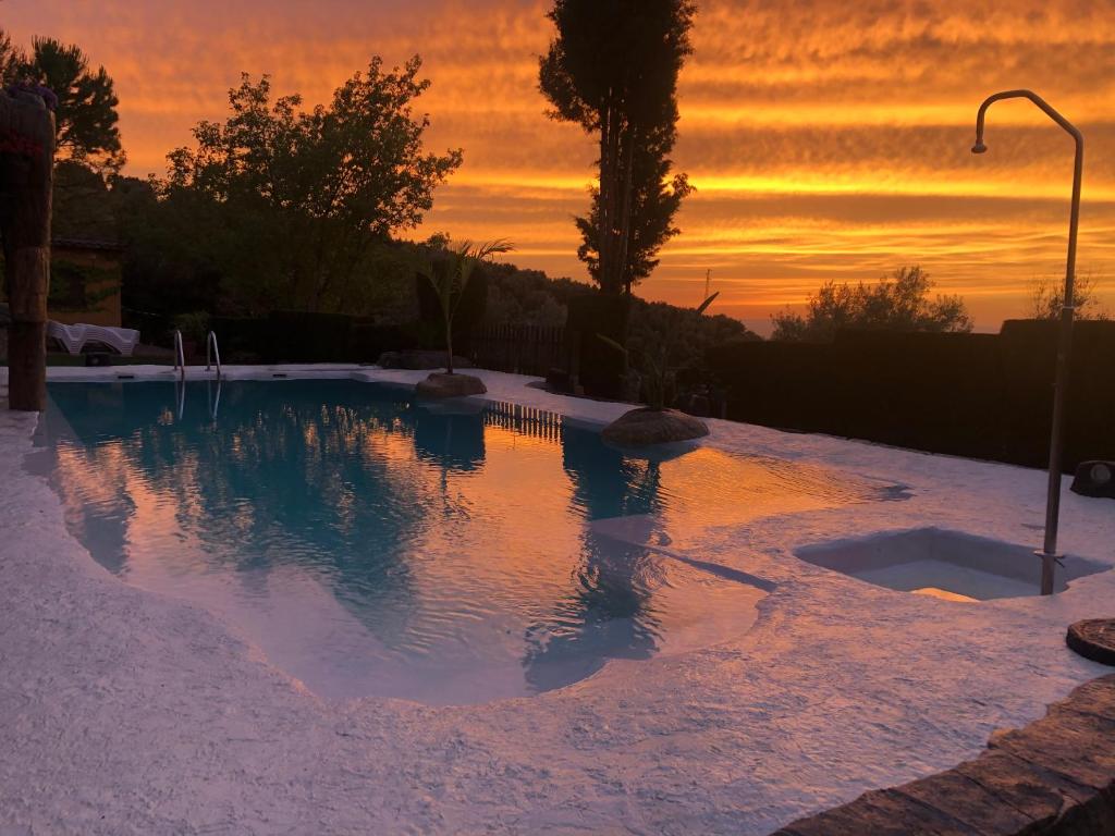 拉伊鲁埃拉Cabañas De Madera Y Bungalows - Gilmañas 3的一座享有日落美景的游泳池