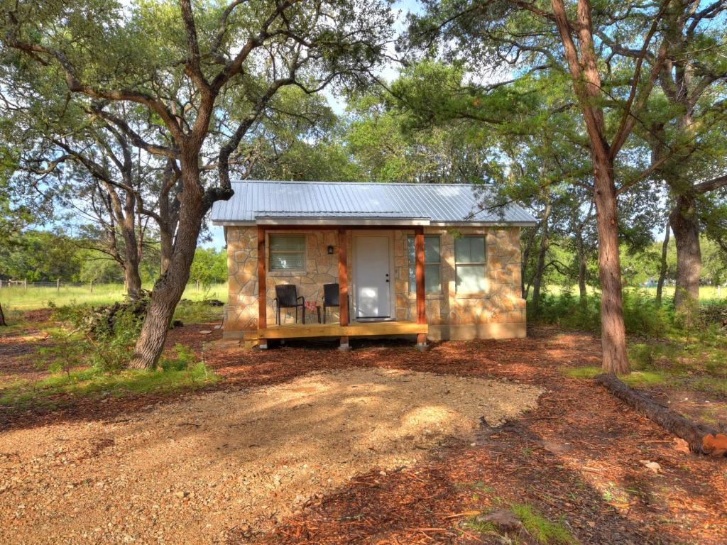 温伯利Cabins at Flite Acres-Mockingbird Cabin的森林中间的小房子