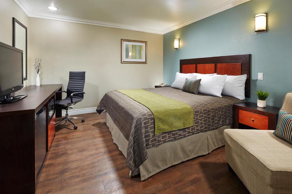 唐尼美国唐尼酒店的配有一张床和一张书桌的酒店客房