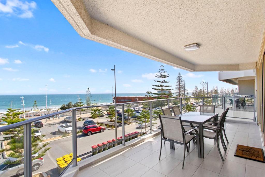珀斯Suite 310 Sandcastles 3 Bedroom Deluxe的阳台配有桌椅,享有海景。