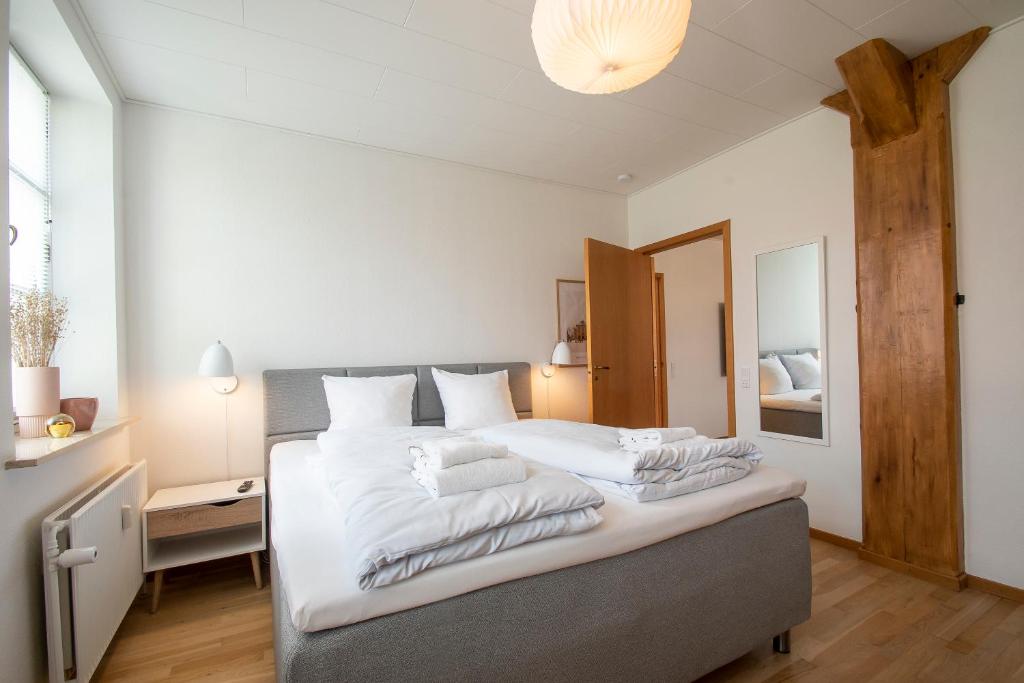 森讷堡Exclusive 2 Bedroom Apartment的一间卧室配有一张带白色床单的大床