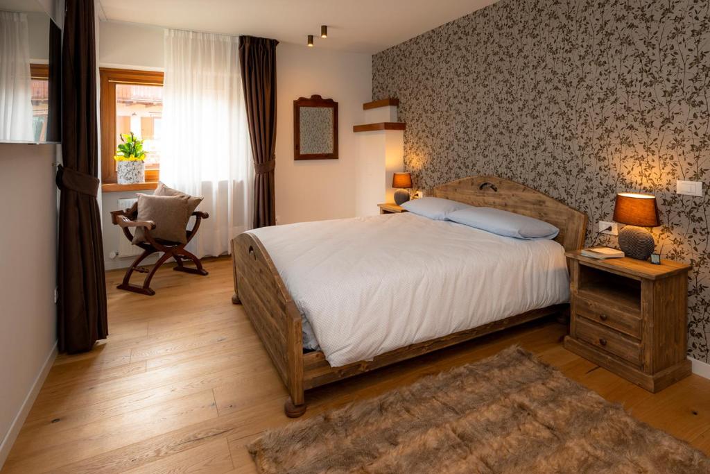 罗阿纳Larici Rooms的一间卧室配有一张床、一张桌子和一把椅子
