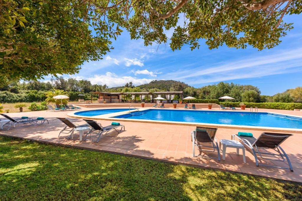 卡拉博纳圣科尔布精品酒店的一个游泳池的形象,游泳池周围摆放着椅子