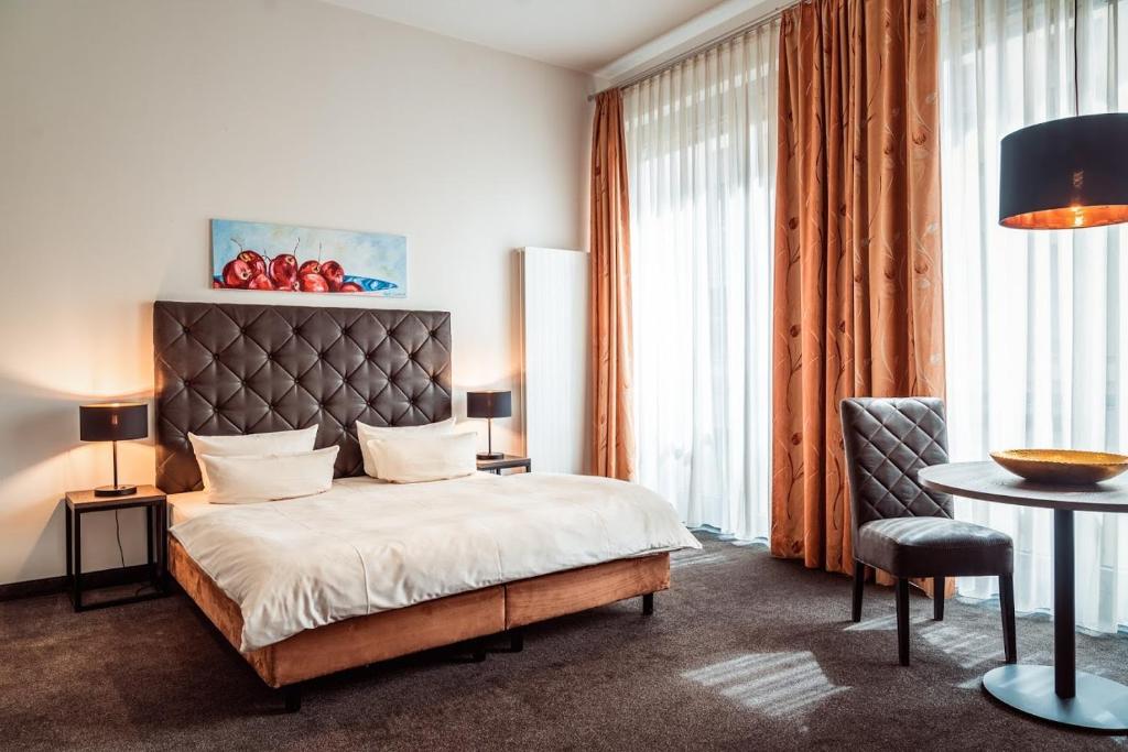 德累斯顿诺伊马克特公寓酒店的卧室配有1张床、1张桌子和1把椅子