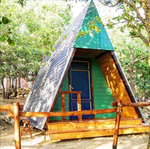 波利齐杰内罗萨HAPPY GLAMPING MADONIE的一个带金字塔屋顶的绿色小屋