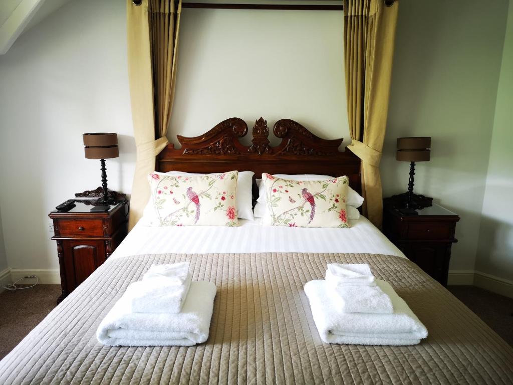 贝图瑟科伊德艾伯康威别墅酒店的一间卧室配有带毛巾的床