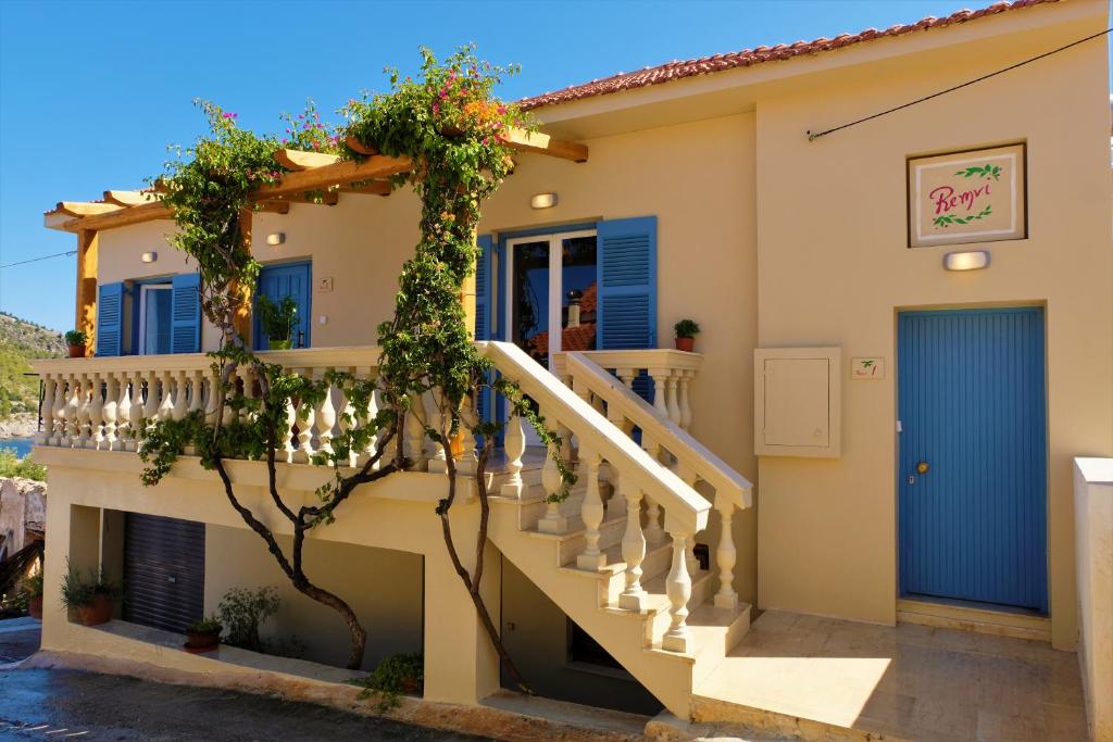 阿索斯REMVI Apartments Assos的一座带楼梯和蓝色门的房子