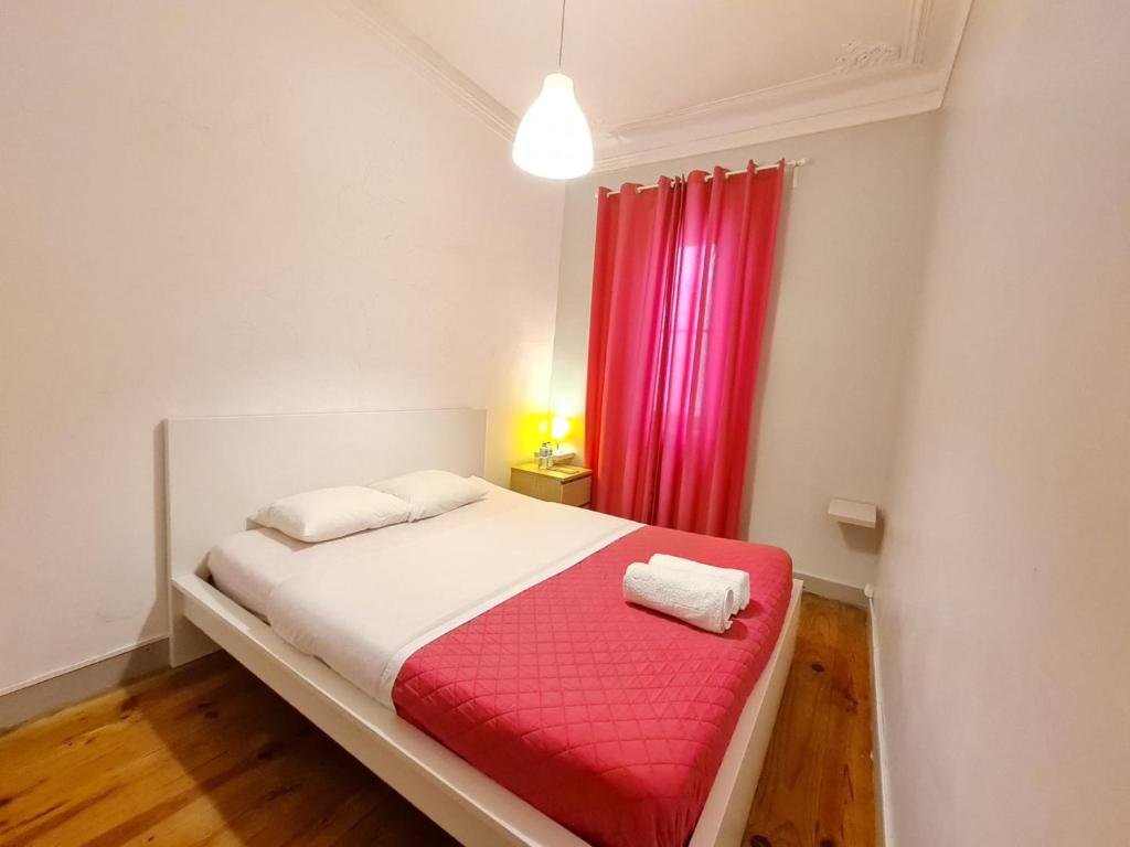 里斯本Shangri-La Hostel Anjos的一间卧室配有一张带红色窗帘的床